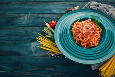 Domatesli makarna makarna. Ahşap bir arka plan üzerinde. İtalyan mutfağı. Üstten Görünüm. Kopya alanı.