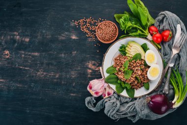 Karabuğday avokado, ıspanak ve haşlanmış yumurta. Ahşap bir arka plan üzerinde. Üstten görünüm. Kopya alanı.