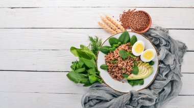 Karabuğday avokado, ıspanak ve haşlanmış yumurta. Ahşap bir arka plan üzerinde. Üstten görünüm. Kopya alanı.