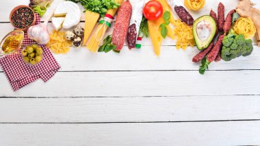 İtalyan sosisi, peynir ve sebze. Beyaz ahşap zemin üzerinde. Üstten görünüm. Kopya alanı.