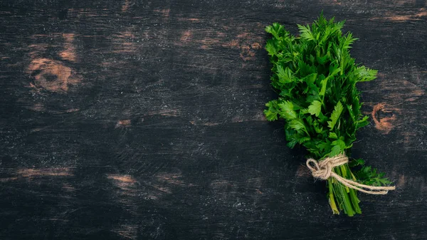 Fresh parsley. On a black wooden background. Top view. Copy space.