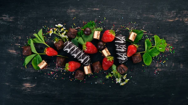 ストロベリー チョコレートとキャンディ 木製黒地 平面図です コピー スペース — ストック写真