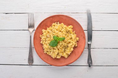 Bulgur bir plaka üzerinde Fesleğenli. Ahşap bir arka plan üzerinde. Üstten görünüm. Kopya alanı.