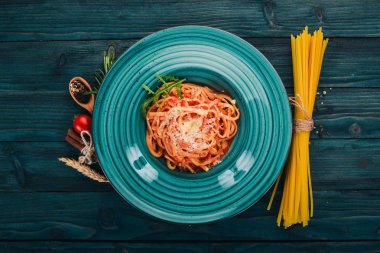 Domatesli makarna makarna. Ahşap bir arka plan üzerinde. İtalyan mutfağı. Üstten Görünüm. Kopya alanı.