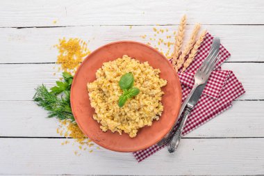 Bulgur bir plaka üzerinde Fesleğenli. Ahşap bir arka plan üzerinde. Üstten görünüm. Kopya alanı.