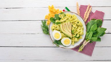 Makarna ıspanak, avokado ve haşlanmış yumurta. Ahşap bir arka plan üzerinde. Üstten görünüm. Kopya alanı.