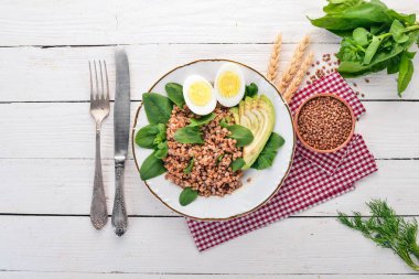 Karabuğday avokado, ıspanak ve haşlanmış yumurta. Ahşap bir arka plan üzerinde. Üstten görünüm. Kopya alanı.