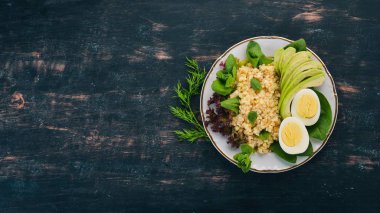 Bulgur avokado, ıspanak ve haşlanmış yumurta. Ahşap bir arka plan üzerinde. Üstten görünüm. Kopya alanı.