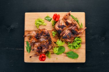 Ahşap oyun tahtası sebzeli fırında bıldırcın. Ahşap bir arka plan üzerinde. Üstten görünüm. Kopya alanı.