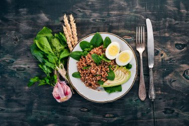 Karabuğday avokado, ıspanak ve haşlanmış yumurta. Ahşap bir arka plan üzerinde. Üstten görünüm. Kopya alanı.