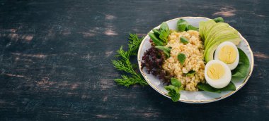 Bulgur avokado, ıspanak ve haşlanmış yumurta. Ahşap bir arka plan üzerinde. Üstten görünüm. Kopya alanı.