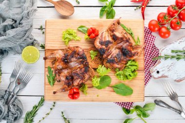 Ahşap oyun tahtası sebzeli fırında bıldırcın. Ahşap bir arka plan üzerinde. Üstten görünüm. Kopya alanı.