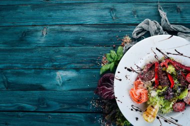 Somon ve domates salatası. İtalyan mutfağı. Ahşap bir arka plan üzerinde. Üstten görünüm. Kopya alanı.