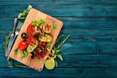 Bir ahşap tahta üzerinde ızgara sebze. Ahşap bir arka plan üzerinde. Üstten görünüm. Kopya alanı.