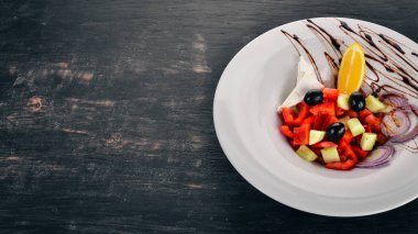 Brie peyniri ile Yunan sebze salatası. Ahşap bir arka plan üzerinde. Üstten görünüm. Kopya alanı.