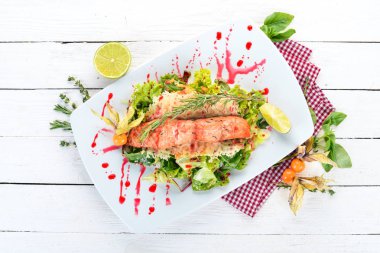 Fırında somon ve sebze salatası. Ahşap bir arka plan üzerinde. Üstten görünüm. Kopya alanı.