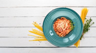 Domatesli makarna makarna. Ahşap bir arka plan üzerinde. İtalyan mutfağı. Üstten Görünüm. Kopya alanı.