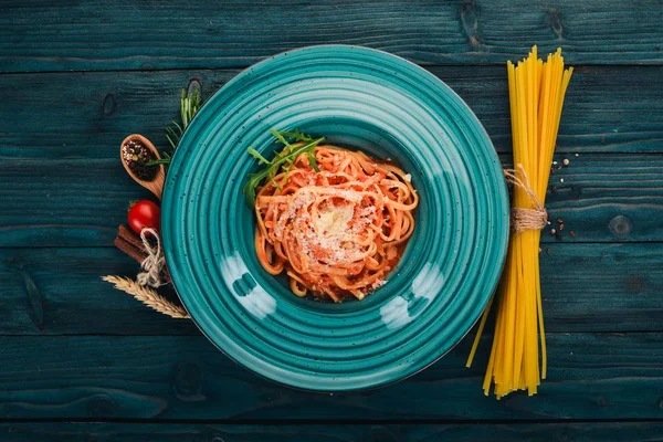 Domatesli makarna makarna. Ahşap bir arka plan üzerinde. İtalyan mutfağı. Üstten Görünüm. Kopya alanı.