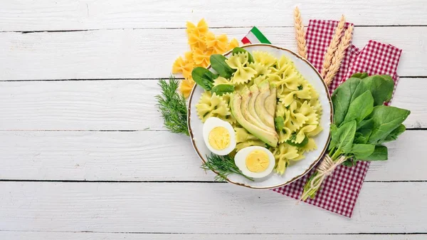 Makarna ıspanak, avokado ve haşlanmış yumurta. Ahşap bir arka plan üzerinde. Üstten görünüm. Kopya alanı.