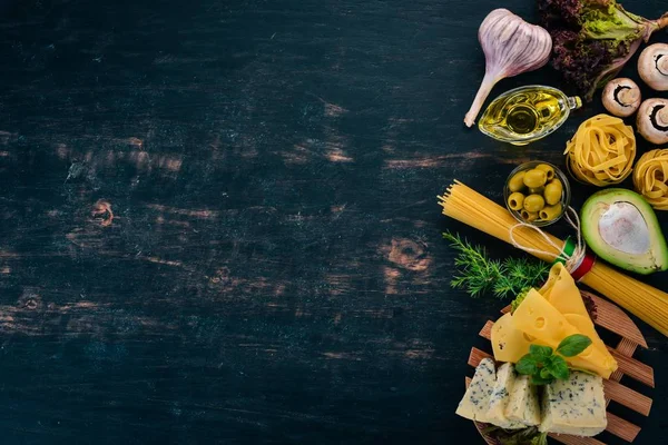 Makarna ve peynir çeşitler. İtalyan mutfağı. Ahşap bir arka plan üzerinde. Üstten görünüm. Kopya alanı.