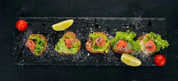 Sandviç somon ve salata ile bırakır. Ahşap bir arka plan üzerinde. Üstten görünüm. Kopya alanı.