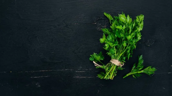 Fresh parsley. On a black wooden background. Top view. Copy space.