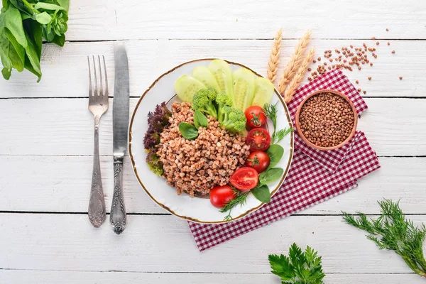 Karabuğday salatalık, brokoli ve domates ile. Ahşap bir arka plan üzerinde. Üstten görünüm. Kopya alanı.