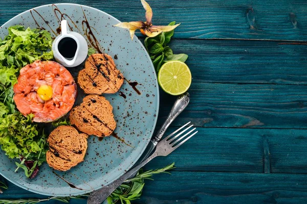 Tartar somon ve avokado. Ahşap bir arka plan üzerinde. Üstten görünüm. Kopya alanı