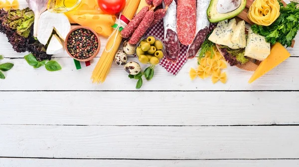 Sosis, peynir ve taze sebze ürün yelpazesine. Beyaz ahşap zemin üzerinde. Üstten görünüm. Kopya alanı.