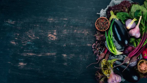 Purple food. Fresh vegetables and berries. On a wooden background. Top view. Copy space.