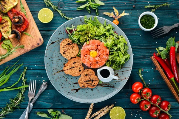 Tartar somon ve avokado. Ahşap bir arka plan üzerinde. Üstten görünüm. Kopya alanı