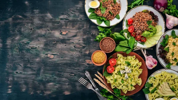 Buğday, bulgur ve makarna gıda kümesi. Ahşap bir arka plan üzerinde. Üstten görünüm. Kopya alanı.