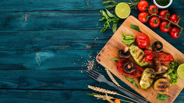 Bir ahşap tahta üzerinde ızgara sebze. Ahşap bir arka plan üzerinde. Üstten görünüm. Kopya alanı.