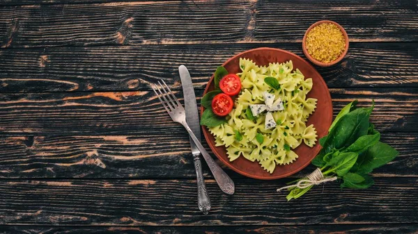 Ispanak ve mavi peynirli makarna. Ahşap bir arka plan üzerinde. Üstten görünüm. Kopya alanı.