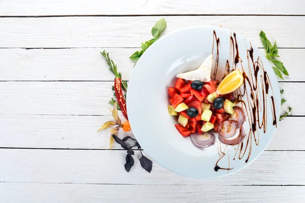 Brie peyniri ile Yunan sebze salatası. Ahşap bir arka plan üzerinde. Üstten görünüm. Kopya alanı.