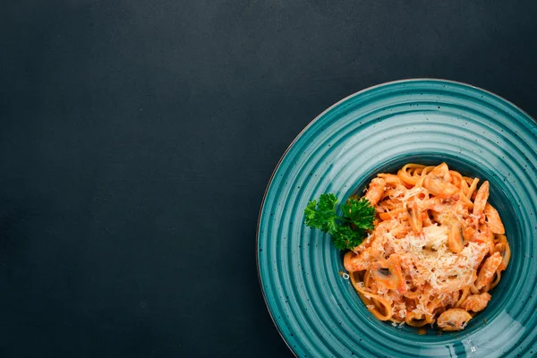 Makarna Tavuk ve mantar ile. İtalyan mutfağı. Ahşap bir arka plan üzerinde. Üstten görünüm. Kopya alanı.