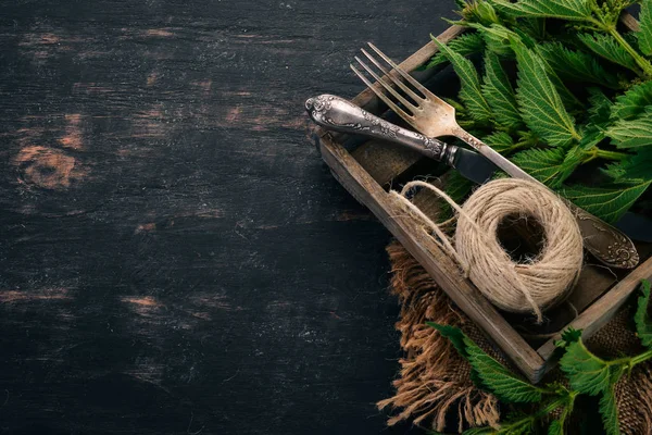 Siyah ahşap zemin taze ısırgan. Üstten görünüm. Kopya alanı.