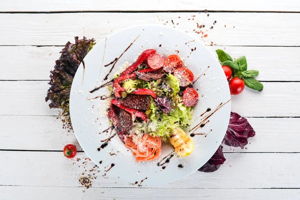 Somon ve domates salatası. İtalyan mutfağı. Ahşap bir arka plan üzerinde. Üstten görünüm. Kopya alanı.