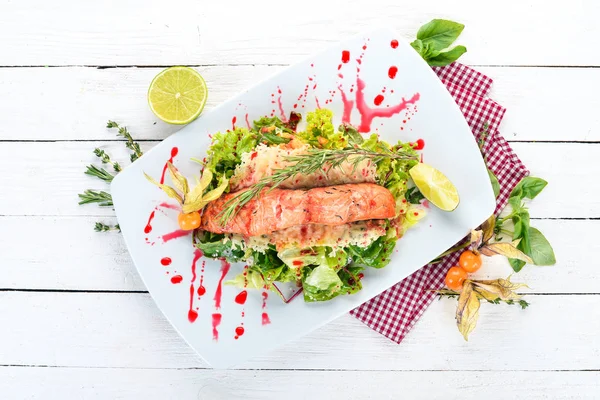 Fırında somon ve sebze salatası. Ahşap bir arka plan üzerinde. Üstten görünüm. Kopya alanı.