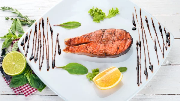 Limon ile pişmiş somon fileto. Kırmızı balık. Ahşap bir arka plan üzerinde. Üstten görünüm. Ücretsiz kopya alanı.