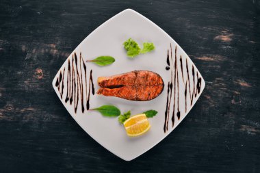 Limon ile pişmiş somon fileto. Kırmızı balık. Ahşap bir arka plan üzerinde. Üstten görünüm. Ücretsiz kopya alanı.