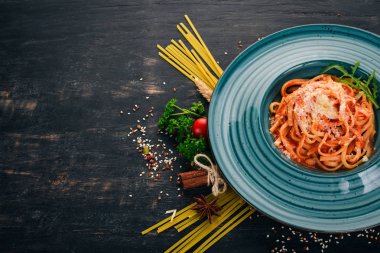 Domatesli makarna makarna. Ahşap bir arka plan üzerinde. İtalyan mutfağı. Üstten Görünüm. Kopya alanı.