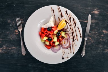 Brie peyniri ile Yunan sebze salatası. Ahşap bir arka plan üzerinde. Üstten görünüm. Kopya alanı.