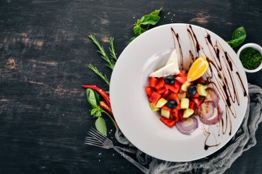 Brie peyniri ile Yunan sebze salatası. Ahşap bir arka plan üzerinde. Üstten görünüm. Kopya alanı.