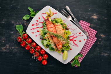 Fırında somon ve sebze salatası. Ahşap bir arka plan üzerinde. Üstten görünüm. Kopya alanı.