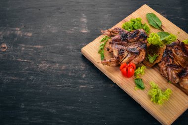 Ahşap oyun tahtası sebzeli fırında bıldırcın. Ahşap bir arka plan üzerinde. Üstten görünüm. Kopya alanı.