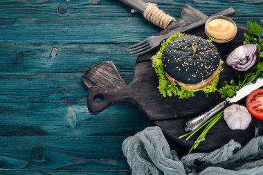 Siyah burger et, soğan ve marul. Ahşap bir arka plan üzerinde. Üstten görünüm. Kopya alanı.