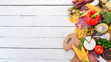 Sosis, peynir ve taze sebze ürün yelpazesine. Beyaz ahşap zemin üzerinde. Üstten görünüm. Kopya alanı.