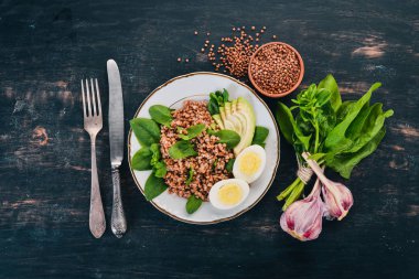 Karabuğday avokado, ıspanak ve haşlanmış yumurta. Ahşap bir arka plan üzerinde. Üstten görünüm. Kopya alanı.