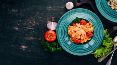 Farfalle makarna domates ve parmesan peyniri. İtalyan mutfağı. Ahşap bir arka plan üzerinde. Üstten görünüm. Kopya alanı.